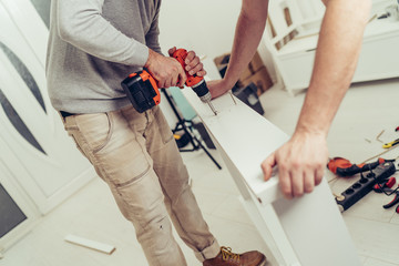 Wall Mural - Two men are renovating and decorating the new apartment.