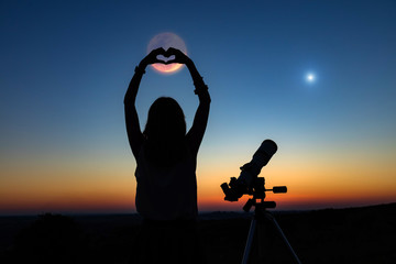 Wall Mural - silhouette of a woman and telescope with twilight sky.