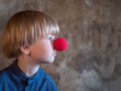 © galitsin - Portrait of charming blond boy in blue shirt with red clown nose and blue ball