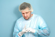 © alenaphoto - Male doctor putting on disposable gloves