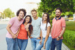 © Studio Romantic - Group of people smiling on a city street in summer.