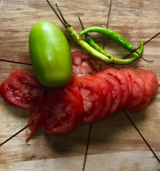 Wall Mural - chili pepper sliced tomato with green tomato on chopping board