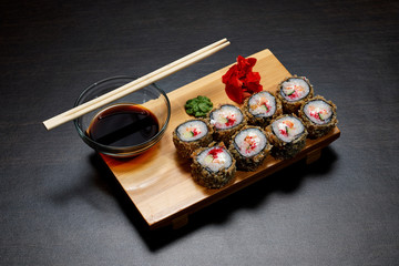 Tasty and delicious hot and cold sushi rolls on the table. Different sushi - rolls with sauce on the board of Japanese cuisine.