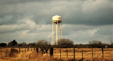 Water Tower On Field Against Sky