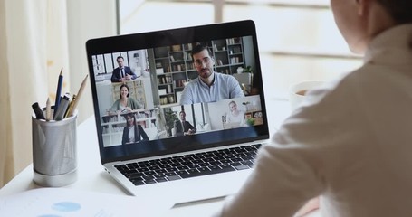 Sticker - Over shoulder view of female remote worker participating group virtual chat meeting by webcam conference chat working from home office. Professional business team on laptop screen online video call.