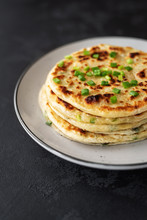 Chinese Green Onion Pancakes On A Black Background. Stack Of Fried Green Onion Pancakes. Dark Photo