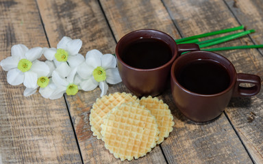 Wall Mural - Two cups with coffee on the table. Breakfast for two. A bouquet of daffodils and coffee in bed.