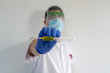 © AventurasxCanarias - Doctor / Nurse with face shield shows the coronavirus vaccine. In his hand he has the vaccine and a syringe. He wears a white uniform, wears a mask, gloves and glasses.