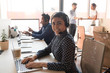 Service phone operator indian woman sitting on shared office room desk wearing headset use laptop looking at camera concept of successful call center professional telemarketing representative portrait