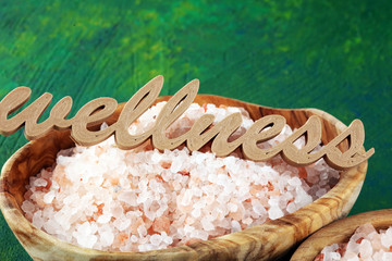 Wall Mural - Crystals of salt on table. himalayan salt in bowl and wellness letters made of wood