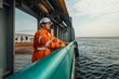 © Igor Kardasov - Filipino deck Officer on deck of vessel or ship , wearing PPE personal protective equipment - helmet, coverall, lifejacket, goggles. Safety at sea. He is tired