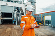 © Igor Kardasov - Filipino deck Officer on deck of offshore vessel or ship , wearing PPE personal protective equipment. He fills checklist. Paperwork at sea