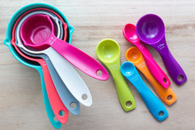 Set Of Colorful Measuring Cups And Measuring Spoons Use In Cooking Lay On Wood Tabletop In Top View.