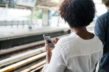 Canvas Print - Woman waiting and playing on her phone