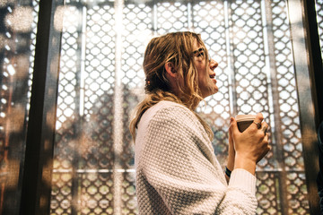 Wall Mural - Blonde woman drinking hot coffee