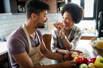 Wall Mural - Happy couple preparing healthy food in kitchen