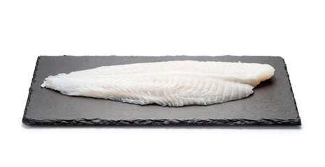 Basa fish fillet on a black stone plate, Isolated on white background.