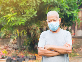 Portrait of elderly man with short white hair, wearing face mask for health because have air pollution PM 2.5. Mask for protect virus, coronavirus, bacteria, pollen grains. Health care concept