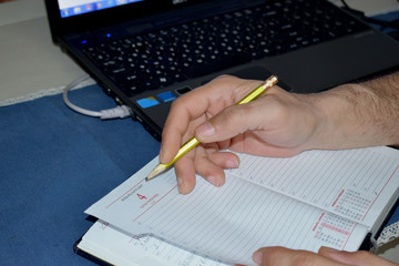 close up of a hand writing on a notebook