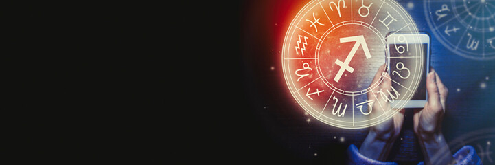 Wall Mural - female hands are holding a phone and an astrological circle with the zodiac sign sagittarius against