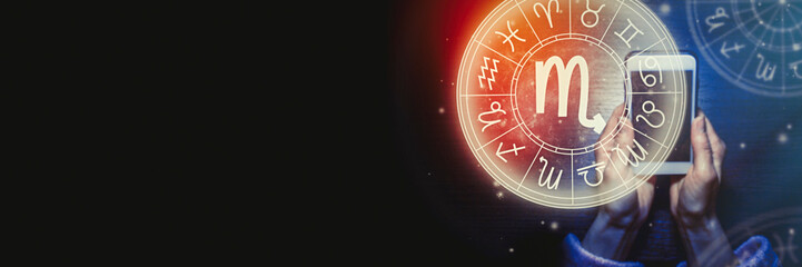 Wall Mural - female hands are holding a phone and an astrological circle with the zodiac sign scorpio on a backgr