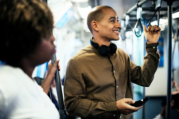 Wall Mural - Man riding a train and holding his smartphone