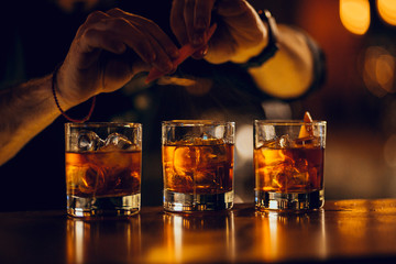 hand making three cocktails on the bar