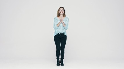 full length of a young woman feeling excited. excited woman in eyeglasses standing over white backgr
