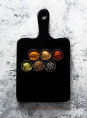 Wall Mural - spices seasoning spicy on a wooden board, top view. Indian spices cooking on gray concrete background