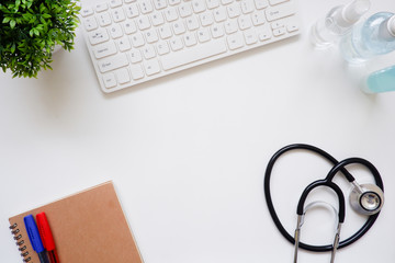 Top view white office desk table with the office equipments, alcohol sanitizer, face mask and other office supplies on the modern space, flat lay.work at home.