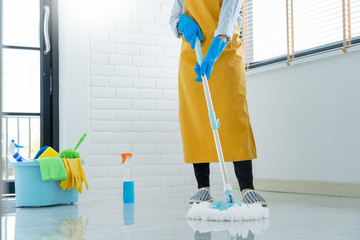 Woman housekeeper with mop and bucket with cleaning agents for cleaning floor at home, Floor care and cleaning services.