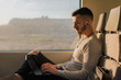 © Cristian Blazquez/ADDICTIVE STOCK - Side view of young man in wireless earphones typing on laptop during journey in subway in sunny day