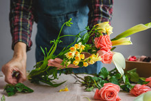 Unrecognizable Female Professional Florist Making Bouquets Of Various Types. Roses. Yellow Flowers. Coves