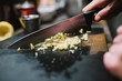 © REMEDIOS PUERTA/ADDICTIVE STOCK - Closeup anonymous person chopping fresh ingredient with sharp knife during cooking course in restaurant kitchen in Navarre, Spain
