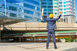 © Pornnarong - Project successful. Engineer celebrating his victory with arms up  on cityscape background.