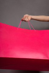 pink bag in hand with copy space, concept of buying, selling, discounts, black friday