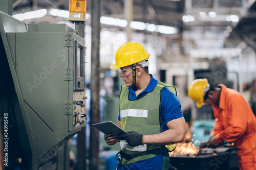 Fotomural technician engineer checking process on tablet to machinery in factory