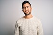© Krakenimages.com - Young handsome man wearing casual sweater standing over isolated white background looking away to side with smile on face, natural expression. Laughing confident.