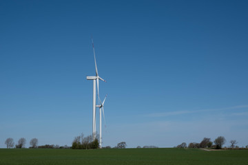 wind energy on a green field, two windmills