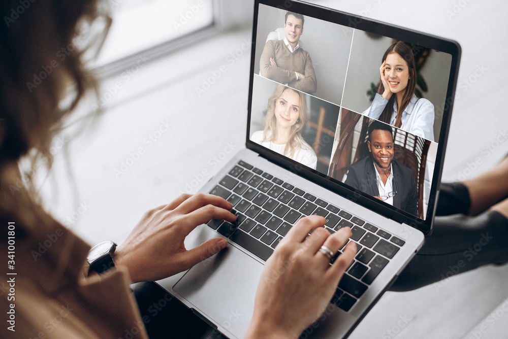 Online business meeting. Business team working from home in a video conference. .The girl communicates via video call communication using laptop with her business colleagues about the future strategy - obrazy, fototapety, plakaty 