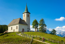 Trekking Cyclist And Church On The Mountain