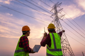 asian manager engineering and worker in standard safety uniform working inspect the electricity high