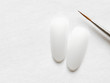 Creative manicure concept. Clean nail tips and paint brush for manicure on white background