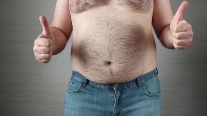 Happy shirtless fat man in jeans showing thumbs up and dancing in slow motion. Big obese belly shaking. Overeating problem concept
