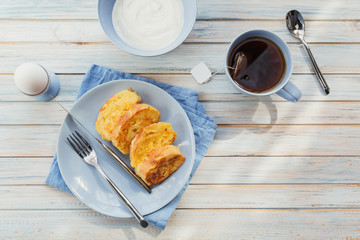 Breakfast with fried croutons, yogurt and black tea on light wooden background. Summer country food.