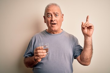 Middle age handsome hoary man drinking glass of water over isolated white background surprised with an idea or question pointing finger with happy face, number one