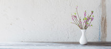 Daphne Flowers In Vase On Old Wooden Table On Background White Wall