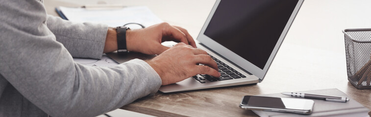Young man working on computer at table indoors, closeup. Banner design