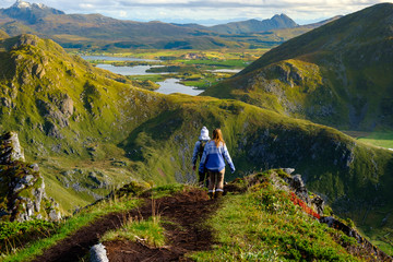 trekking on the lofoten islands, a couple on top of a mountain range