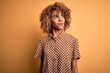 © Krakenimages.com - Young beautiful african american woman wearing casual shirt standing over yellow background smiling looking to the side and staring away thinking.